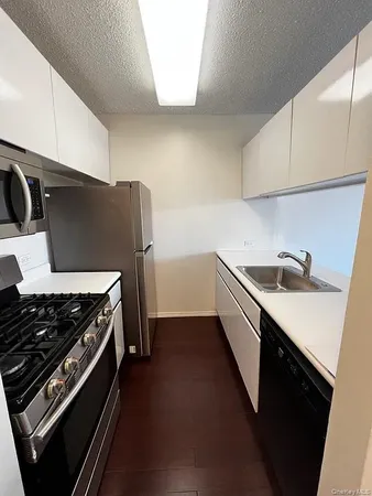 a kitchen with a sink a stove and cabinets