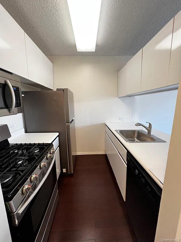 62-54 97th Place, Unit 4G Queens, NY 11374 - Photo 4 of 13 a kitchen with a sink a stove and cabinets