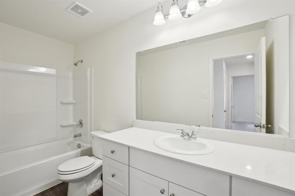 2104 Prairie Lane Melissa, TX 75454 - Photo 15 of 19 a bathroom with a sink a toilet and a large mirror