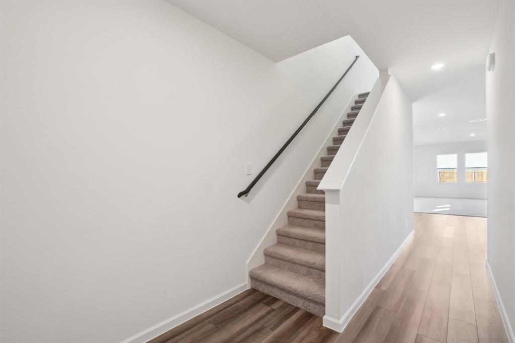 2104 Prairie Lane Melissa, TX 75454 - Photo 18 of 19 a view of staircase with wooden floor and white walls