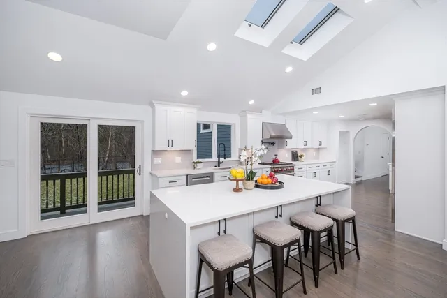 a kitchen with a dining table chairs and refrigerator