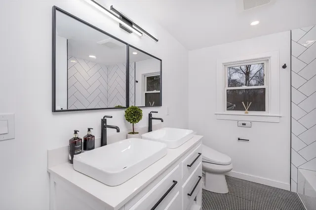 a bathroom with a toilet sink and mirror