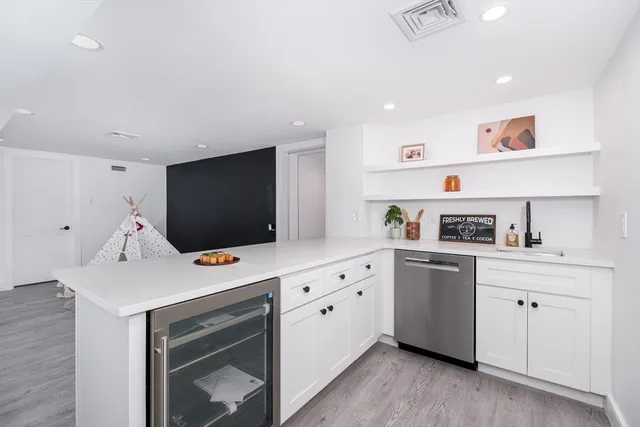 a kitchen that has a lot of cabinets in it and wooden floors