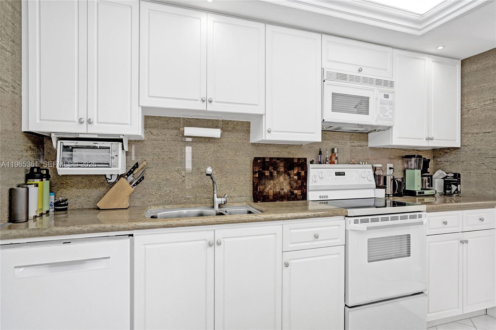 501 North Riverside Drive, Unit 802 Pompano Beach, FL 33062 - Photo 20 of 70 a kitchen with white cabinets and white appliances