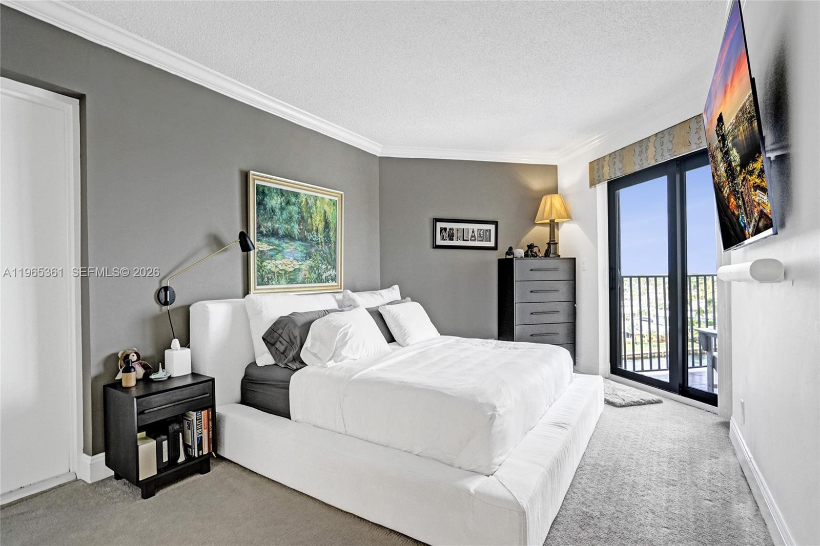 501 North Riverside Drive, Unit 802 Pompano Beach, FL 33062 - Photo 33 of 70 a bedroom with a bed next to a window with a flat screen tv