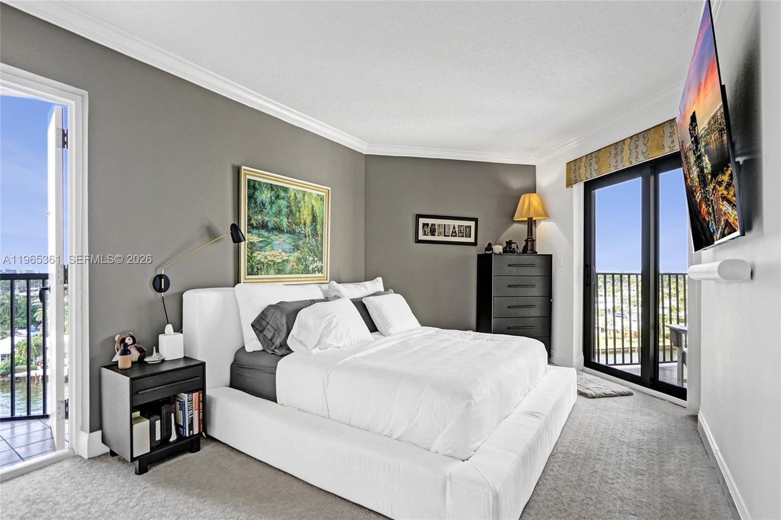 501 North Riverside Drive, Unit 802 Pompano Beach, FL 33062 - Photo 34 of 70 a bedroom with a balcony a bed and a flat screen television