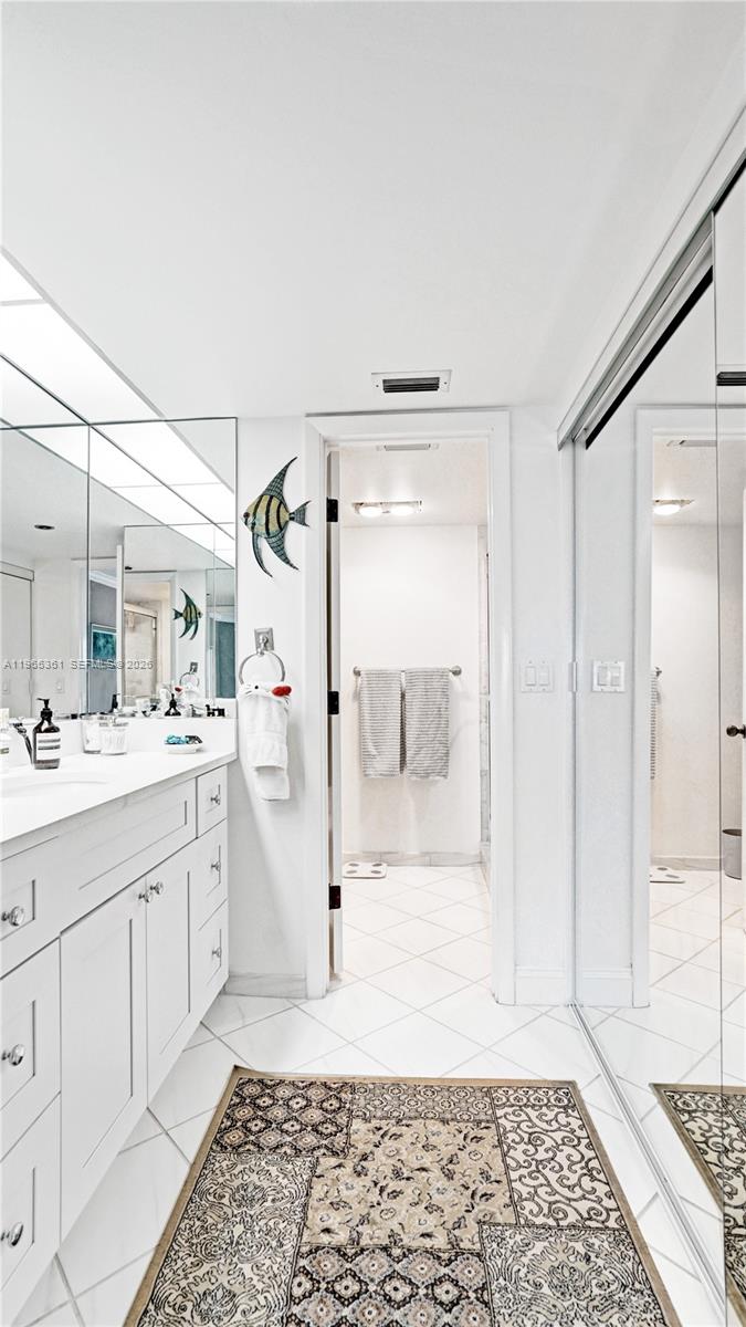 501 North Riverside Drive, Unit 802 Pompano Beach, FL 33062 - Photo 39 of 70 a bathroom with a sink a mirror and a shower