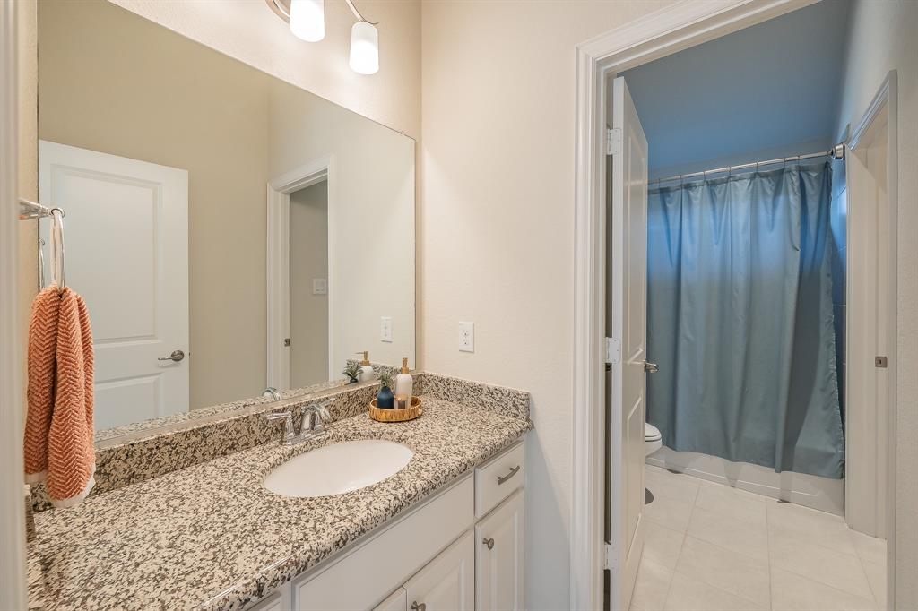 1205 Ivy Charm Way Arlington, TX 76005 - Photo 28 of 40 Vanity with stone countertop, undermount sink, and chrome faucet