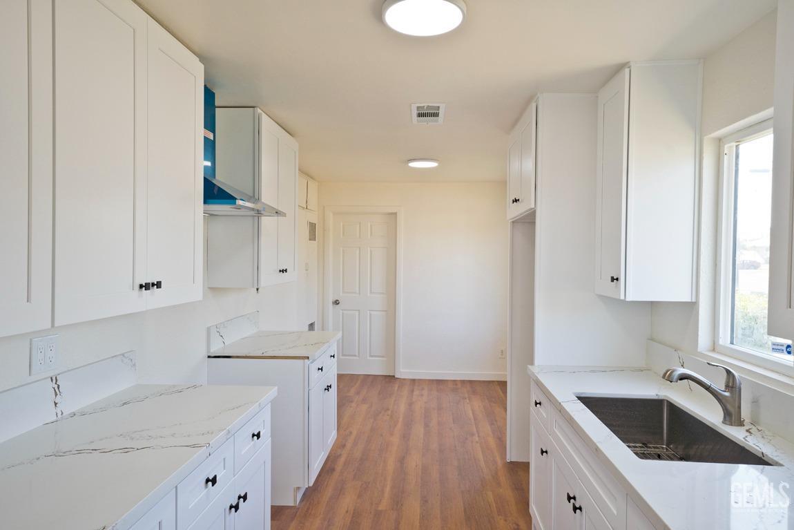 Undisclosed Address Bakersfield, CA 93308 - Photo 11 of 23 a kitchen with granite countertop white cabinets and white appliances