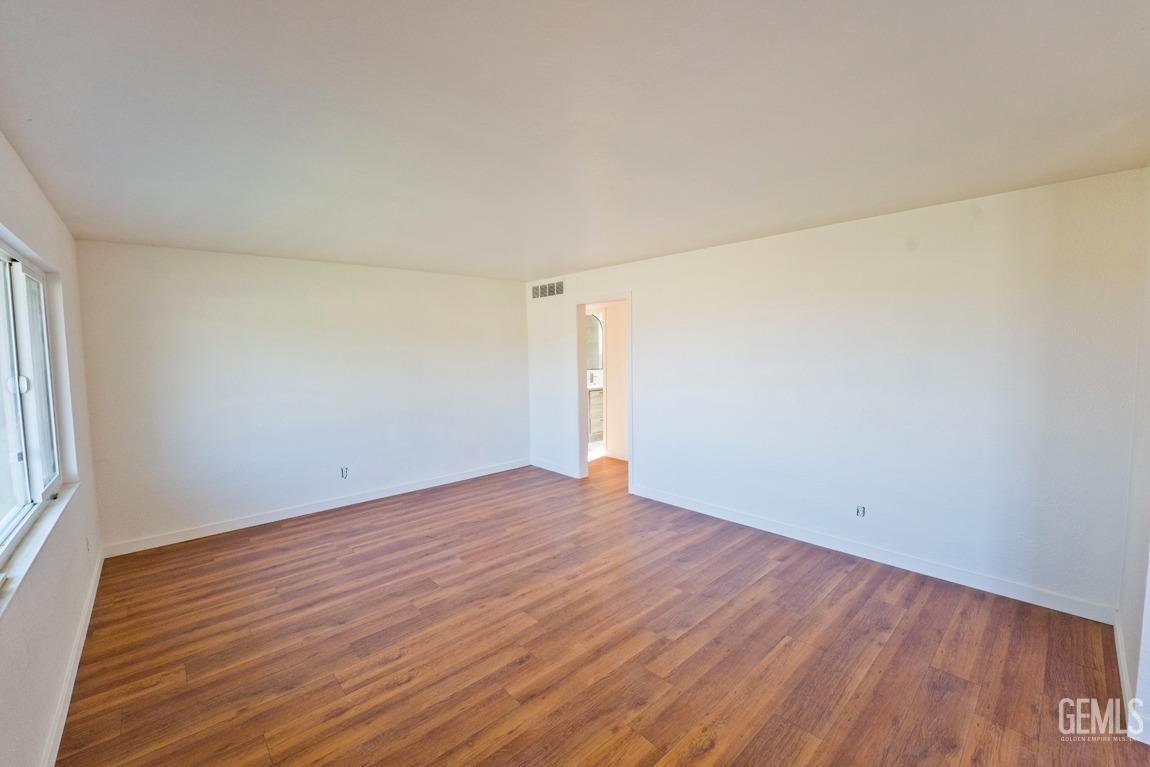 Undisclosed Address Bakersfield, CA 93308 - Photo 7 of 23 an empty room with wooden floor and windows