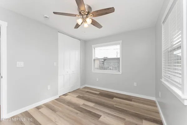 a view of empty room with window and ceiling fan
