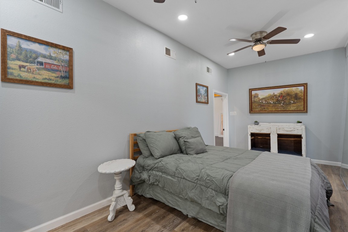 1102 Beech Street Taylor, TX 76574 - Photo 12 of 40 a bedroom with a bed and a chandelier
