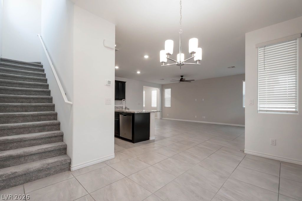 7126 Calvert Cliffs Street North Las Vegas, NV 89084 - Photo 43 of 44 A well-lit open floorplan seamlessly connects the kitchen with a spacious living area and a carpeted staircase.