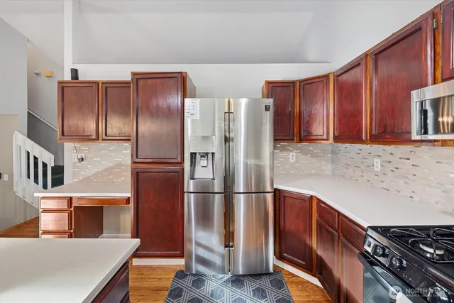 a kitchen with stainless steel appliances granite countertop a refrigerator and a stove