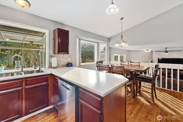 a kitchen with a table chairs stove and wooden floor
