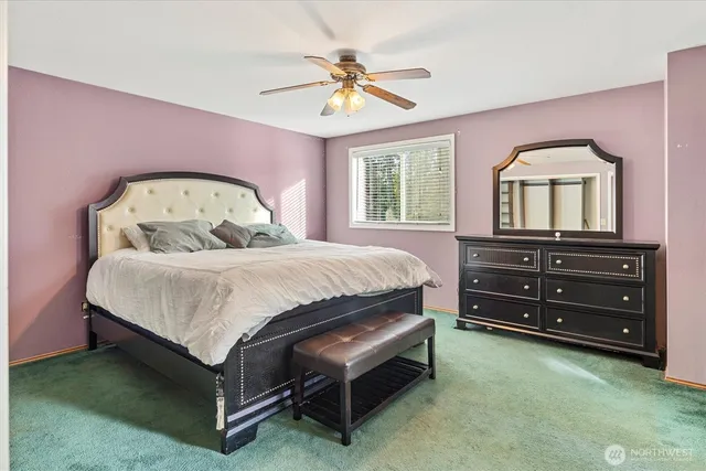 a spacious bedroom with a bed and a dresser