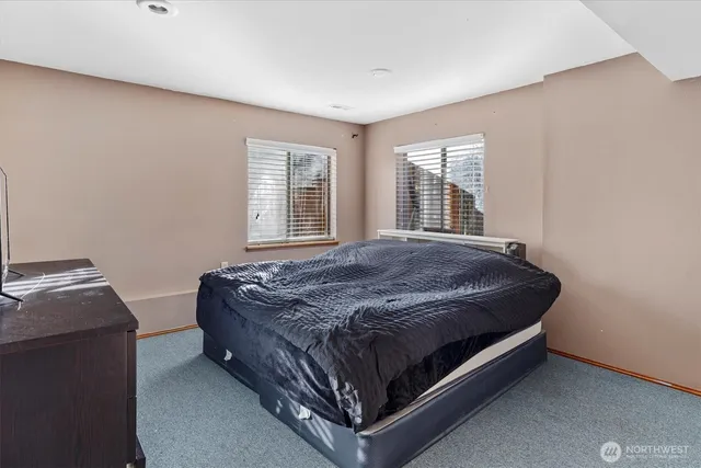 a bed sitting in a bedroom next to a window