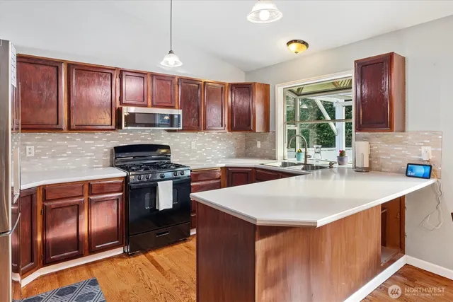 a kitchen with stainless steel appliances granite countertop a sink stove and refrigerator