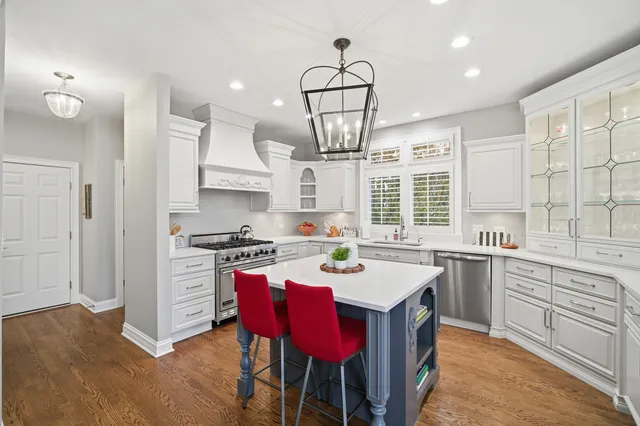 a kitchen with stainless steel appliances a sink a stove a table and chairs