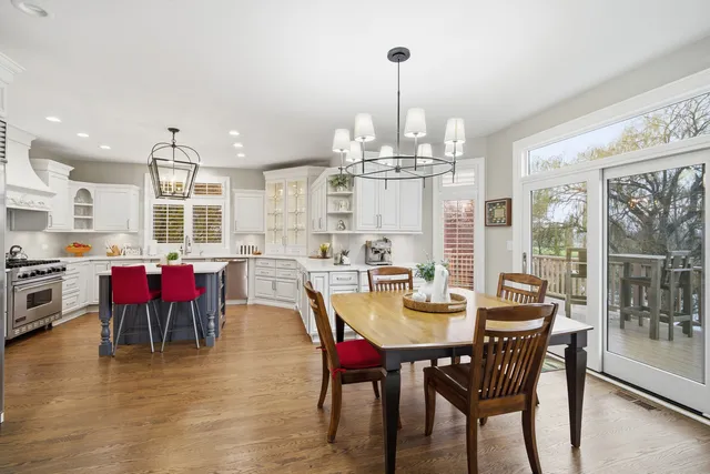 a view of a dining room and livingroom with furniture wooden floor a chandelier