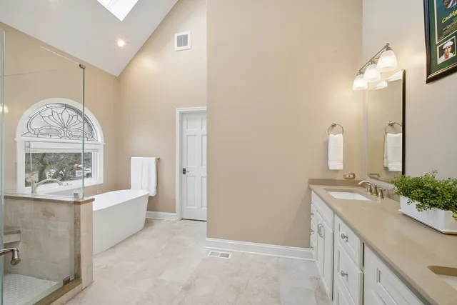 a spacious bathroom with a shower sink and mirror