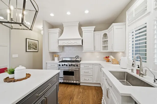 a kitchen with stainless steel appliances a stove a sink and a white cabinets