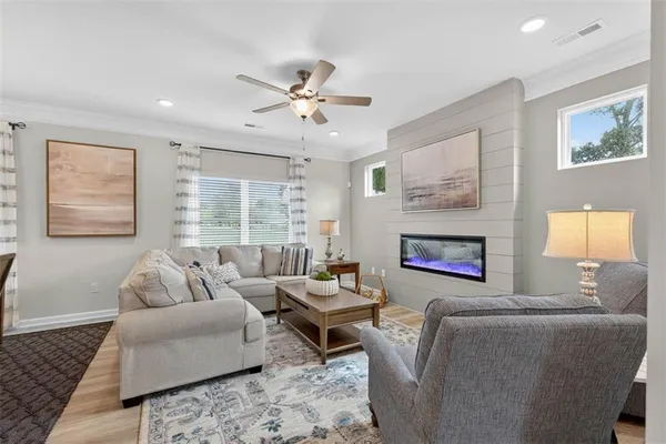 a living room with furniture a large window and a fireplace