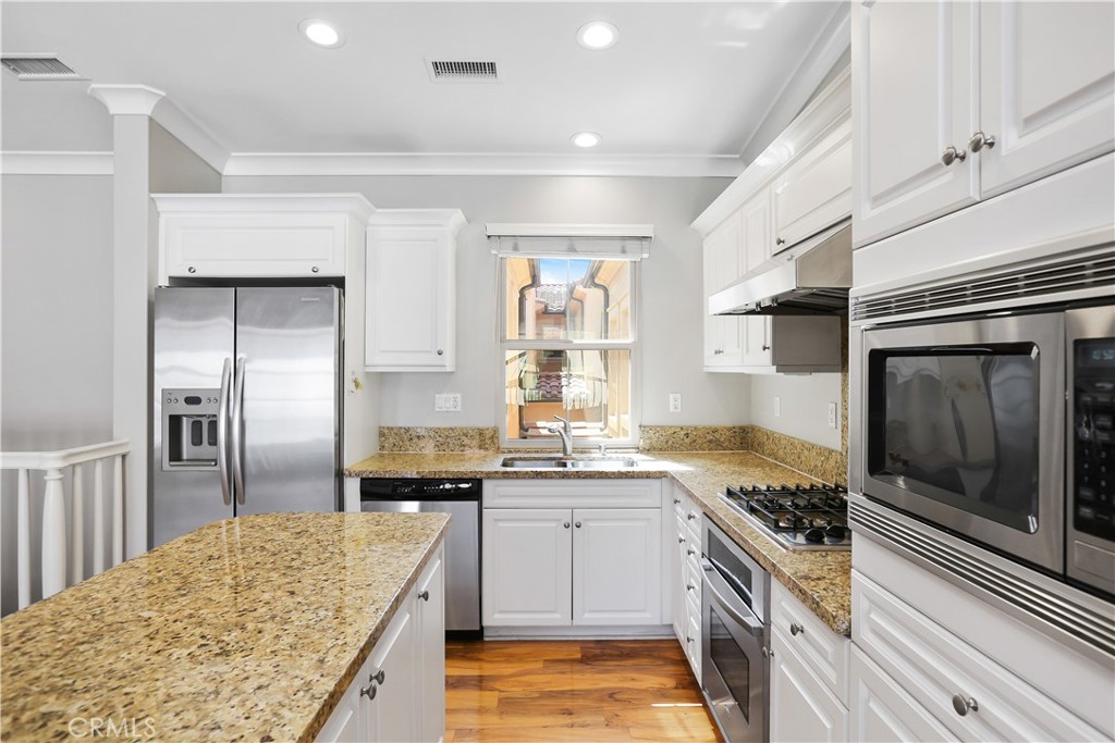 10 Nature Irvine, CA 92620 - Photo 6 of 27 a kitchen with stainless steel appliances kitchen island granite countertop a sink stove and refrigerator