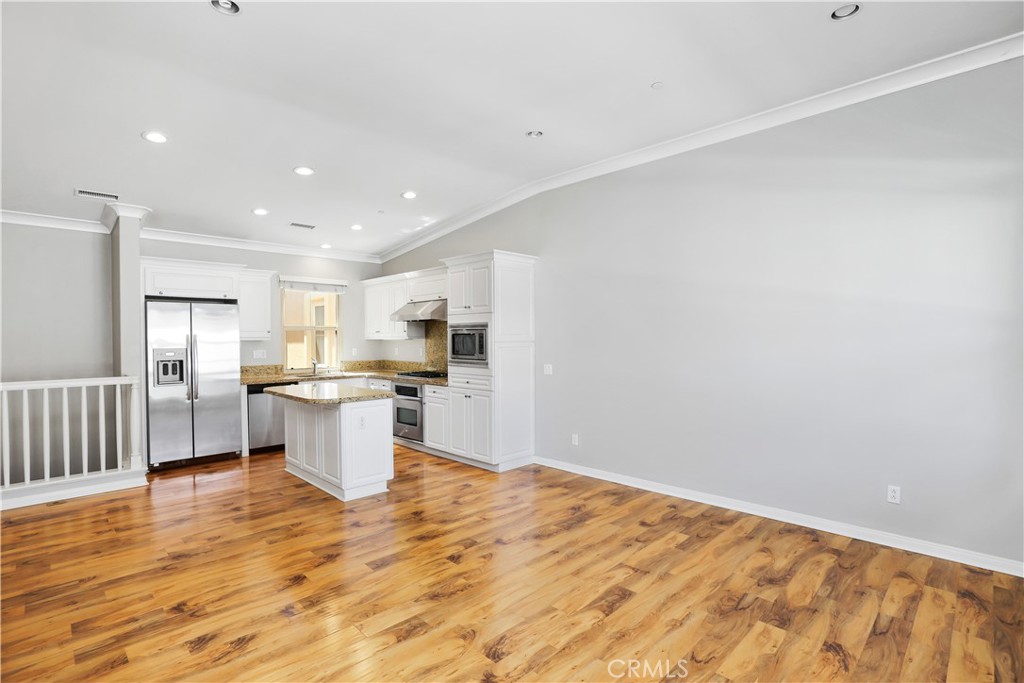 10 Nature Irvine, CA 92620 - Photo 9 of 27 a open kitchen with white cabinets and wooden floor