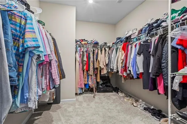 a view of walk in closet with clothes