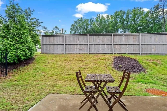 a view of a backyard with table and chairs and wooden fence
