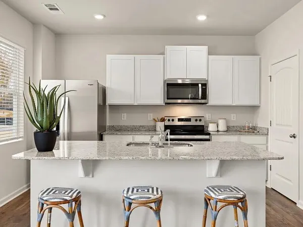 a kitchen with stainless steel appliances granite countertop a stove top oven a sink a counter space and cabinets