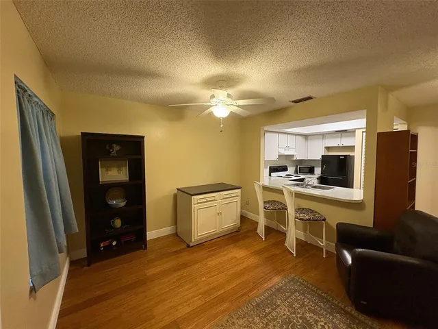 a large kitchen with a refrigerator a stove top oven a sink dishwasher and white cabinets