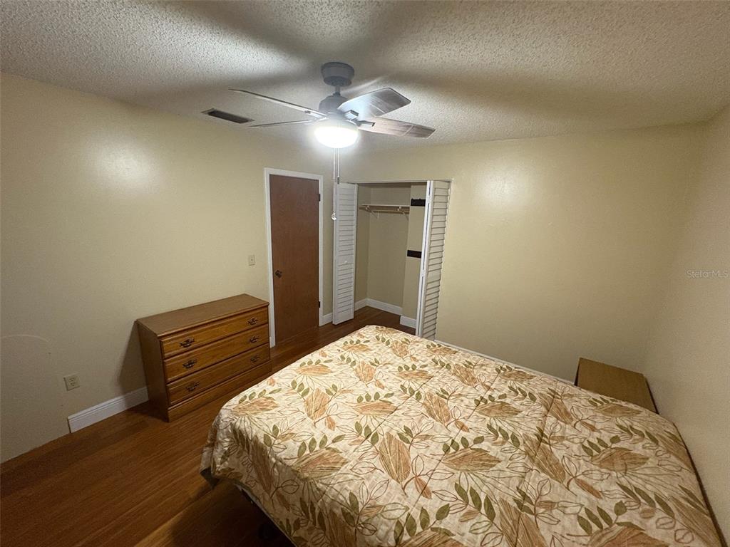 1250 South Pinellas Avenue, Unit 411 Tarpon Springs, FL 34689 - Photo 10 of 29 a bedroom with a bed and wooden floor