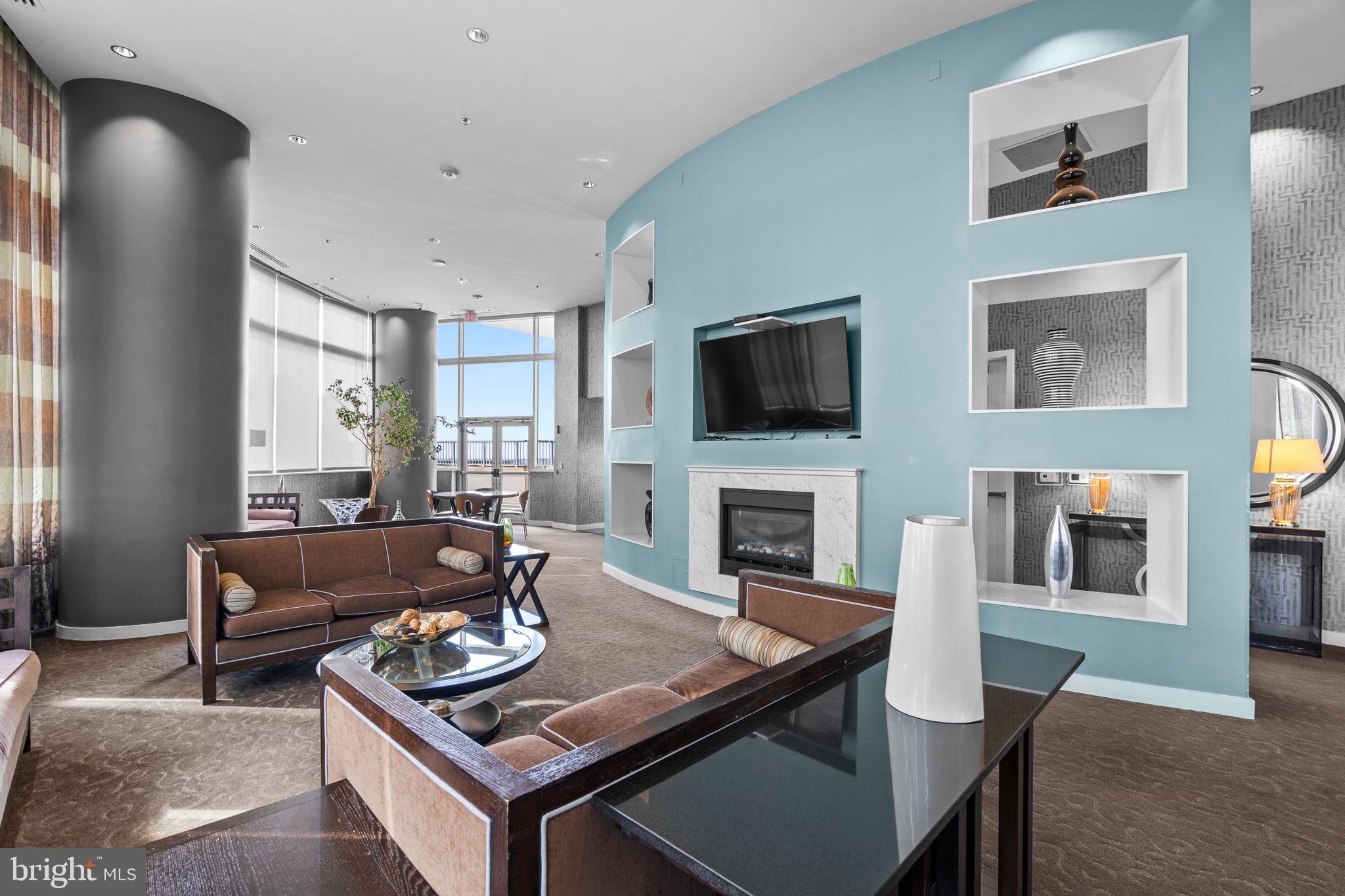 5750 Bou Avenue, Unit 1106 North Bethesda, MD 20852 - Photo 27 of 54 a living room with furniture a flat screen tv and a fireplace