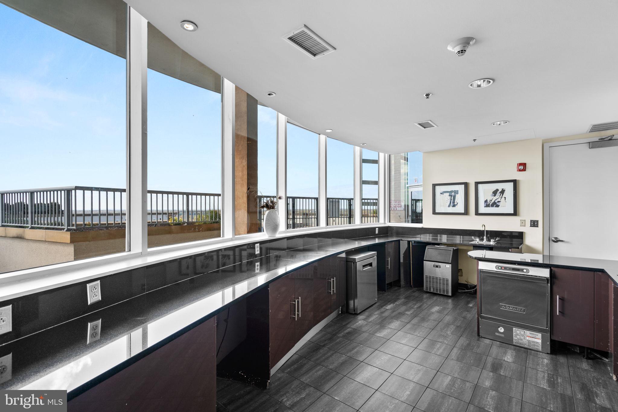 5750 Bou Avenue, Unit 1106 North Bethesda, MD 20852 - Photo 28 of 54 a large kitchen with a large counter top space a sink stainless steel appliances and windows