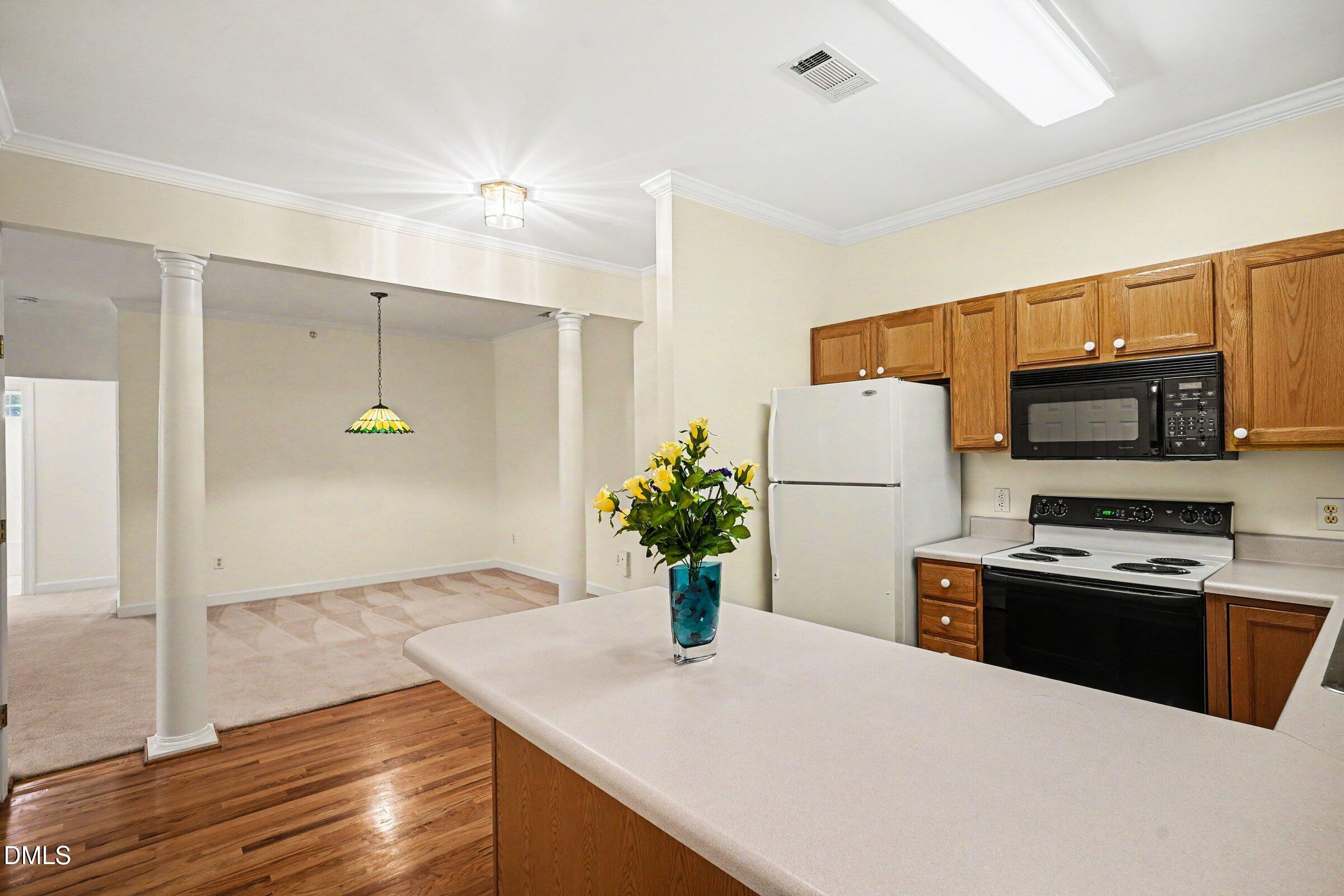 2651 Mellowfield Drive, Unit 203 Raleigh, NC 27604 - Photo 6 of 32 a kitchen that has a microwave a stove and a refrigerator
