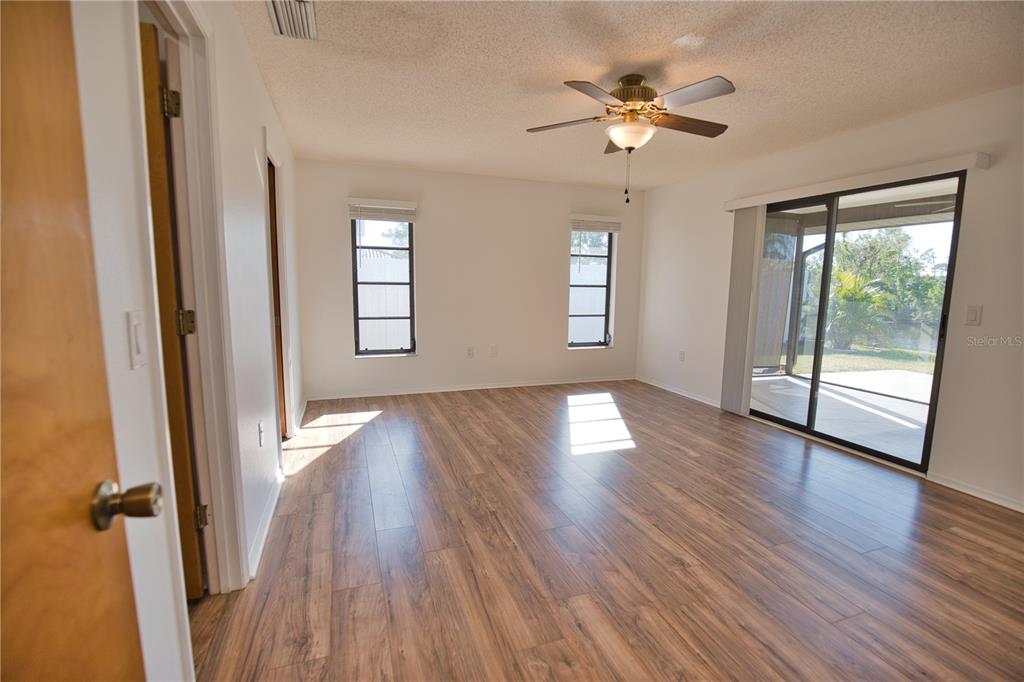 3534 Tundra Road Venice, FL 34293 - Photo 23 of 43 an empty room with wooden floor fan and windows
