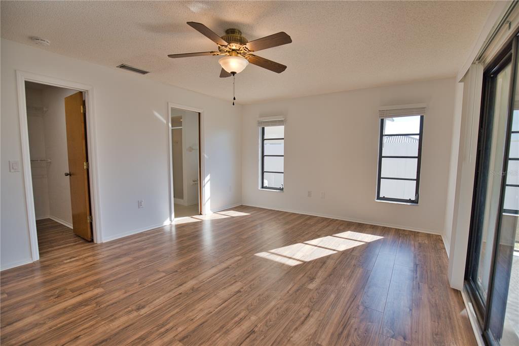 3534 Tundra Road Venice, FL 34293 - Photo 24 of 43 an empty room with wooden floor chandelier fan and windows