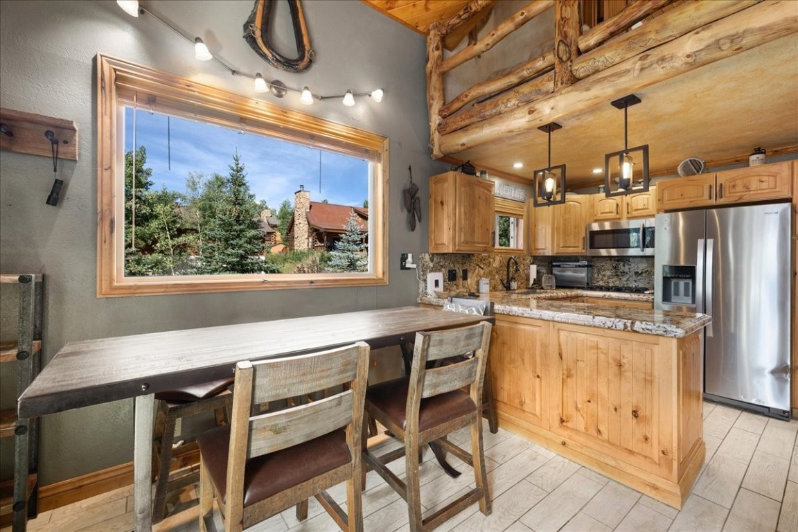 19 East Hanson Road Keystone, CO 80435 - Photo 9 of 24 a kitchen with stainless steel appliances kitchen island granite countertop a table chairs in it and wooden floors