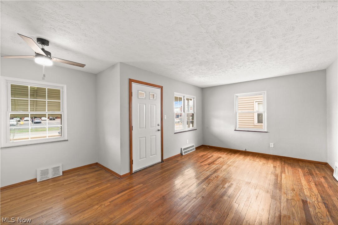 4907 Ridge Road Cleveland, OH 44144 - Photo 6 of 36 Foyer featuring a textured ceiling, hardwood / wood-style floors, and ceiling fan