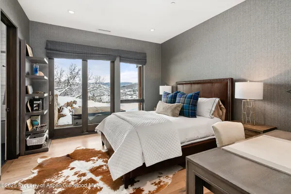 a bedroom with a bed and a large window with the outer view