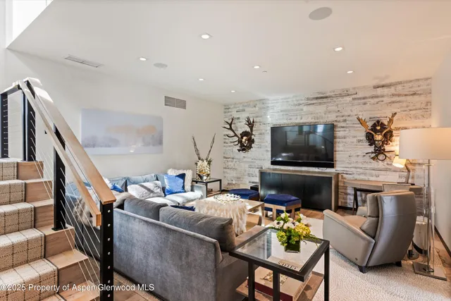 a living room with stainless steel appliances kitchen island granite countertop a refrigerator and a stove top oven