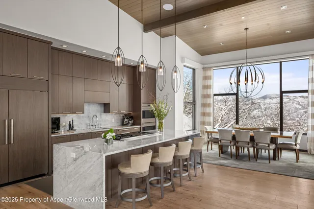 a large kitchen with a large window and stainless steel appliances