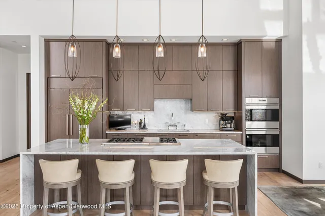 a kitchen with a table chairs and refrigerator