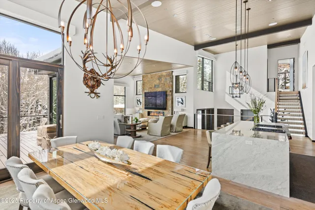 a view of a dining room with furniture a chandelier and wooden floor