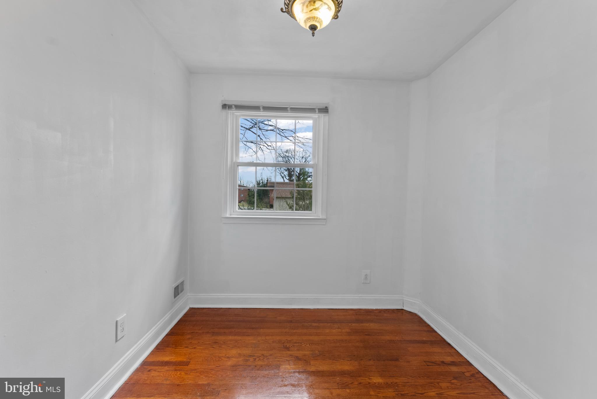633 Walker Avenue Baltimore, MD 21212 - Photo 12 of 27 an empty room with wooden floor and windows