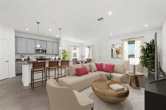 a living room with furniture kitchen and a table