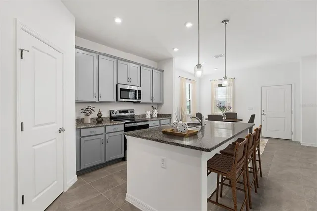 a kitchen that has a sink stainless steel appliances and cabinets