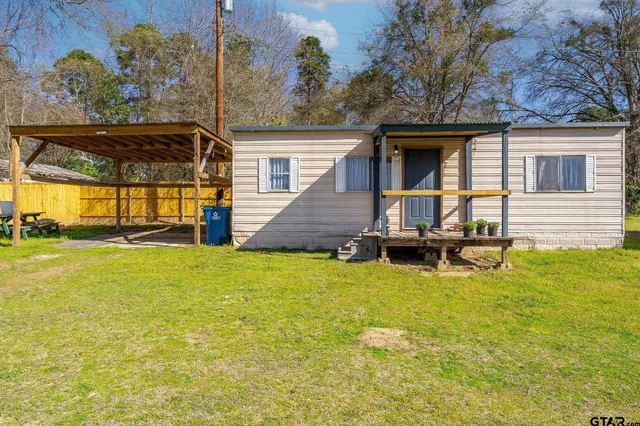 a living room with furniture a flat screen tv and a window